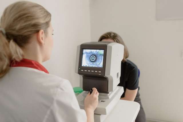 oculist examining vision of patient on eye screener